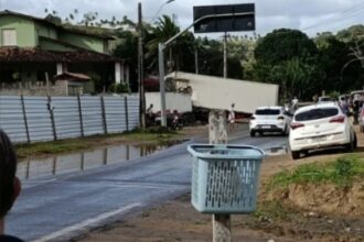 Carreta tomba e atinge muro de residência em Laje; motorista ficou preso nas ferragens