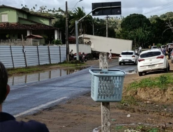 Carreta tomba e atinge muro de residência em Laje; motorista ficou preso nas ferragens