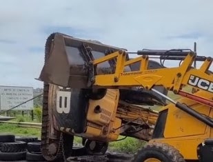 Máquina que caiu de caminhão na BR-420 em Mutuípe é desvirada com auxílio de retroescavadeira