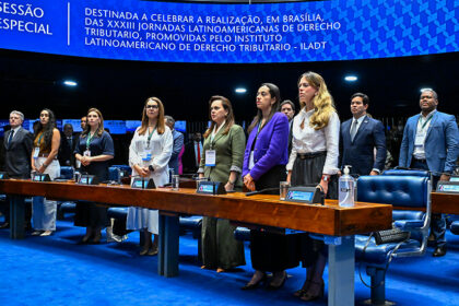 Em posição de respeito, parlamentares e convidados acompanham execução do Hino Nacional.