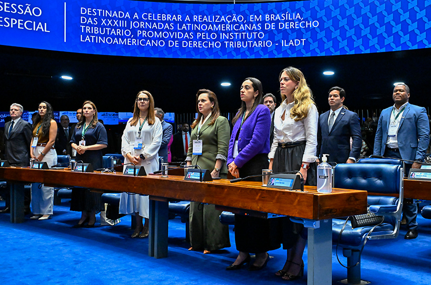 Em posição de respeito, parlamentares e convidados acompanham execução do Hino Nacional.